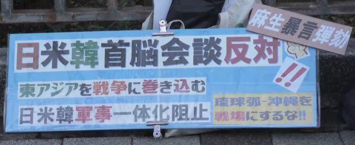日韩民众在日本首相官邸前举牌抗议。