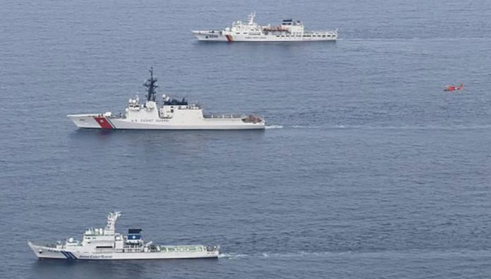 2024年6月6日,日本海上保安厅提供的这张照片显示,日本海上保安厅的巡逻舰“若狭号”(自下而上)、美国海岸警卫队的巡逻舰“韦舍山号”和韩国海洋警察厅的巡逻舰“泰平壤 16 号”以及一架飞行中的直升机(红色)在日本舞鹤北部海岸附近海域参加演习。